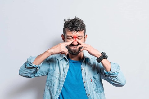 Man with nasal bridge headache, person with pain touching nose. sinus pain concept, A person with