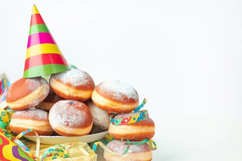 Colourful streamers, paper hats and doughnuts, carnival, copy room, white background