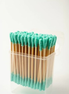 Bamboo cotton swabs, green, on a light background, in a package