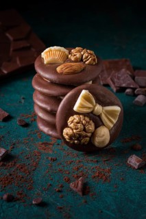 A stack of chocolate mediants, handmade candies, on a dark background, in the style of dark food,