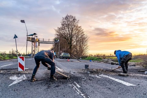 Climate activists chop up the asphalt of a road to erect obstacles, barricades, to prevent the
