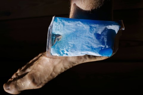 Symbolic photo on the subject of cooling for joint pain. A cooling pad is placed on an ankle and