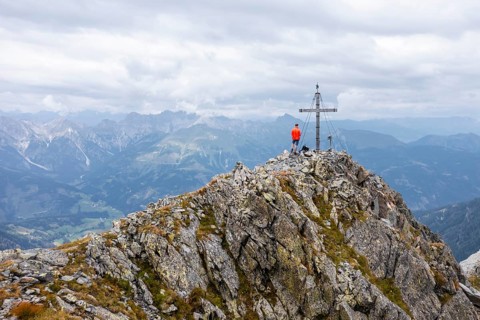 Aerial view, hiker on the Raudenspitze with summit cross, Carnic High Trail, Carnic Main Ridge,