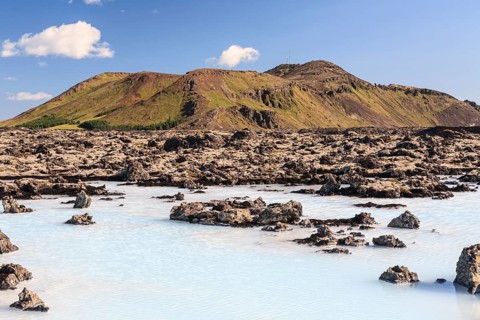 Thermal outdoor pool in front of volcanic mountains, Blue Lagoon, summer, sunny, Grindavik,