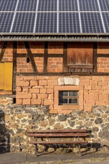 Historic farmhouse with photovoltaic system, solar panels on the roof, house wall with differently