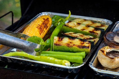 Grilled vegetables consisting of sweetcorn, green peppers and courgettes on a grill with grill