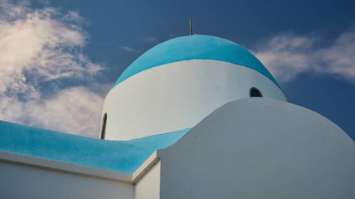 White-blue church with clouds in the background under a blue sky, Church of Profitis Ilias, above