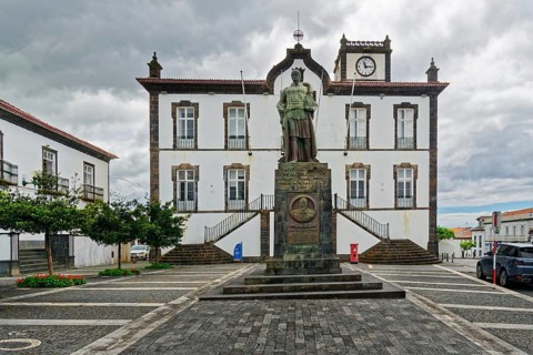 Town square with a statue in front of a historic building with clock tower Largo do Município de