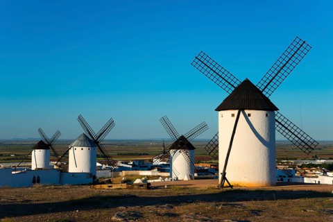 Group of white windmills in front of a vast landscape under a blue sky, Campo de Criptana, Ciudad