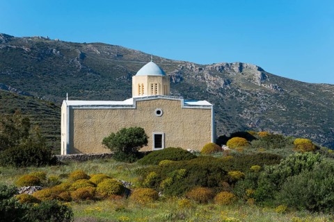 Church in a mountainous, green landscape under a clear sky, Chiesa di Agia Triada, church near