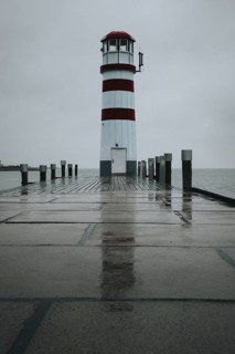 Lighthouse on a wooden jetty, surrounded by a rainy sky, Podersdorf, Burgenland, Austria, Europe