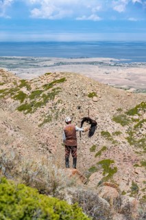 Traditional Kyrgyz eagle hunter hunting in the mountains in a dry landscape, near Kysyl-Suu, Issyk