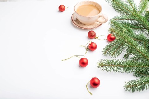 Christmas or New Year composition. Decorations, red balls, fir and spruce branches, cup of coffee,