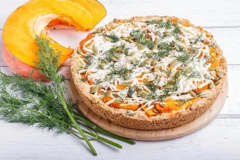 Sweet pumpkin pie with cheese and dill on white wooden background. close up