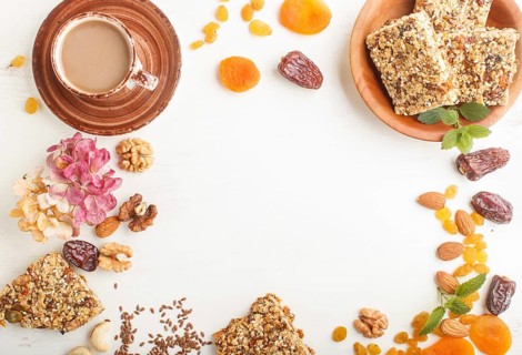 Homemade granola from oat flakes, dates, dried apricots, raisins, nuts with a cup of coffee on a