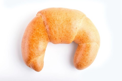 One croissant isolated on white background. closeup. top view