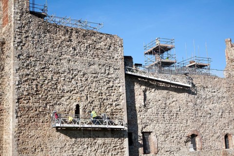 Stonemasons doing maintenance repairs to the stone walls of Framlingham castle, Suffolk, England,