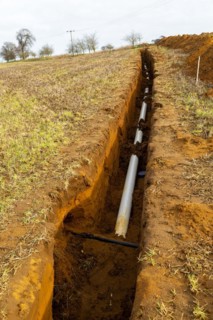 Farm irrigation water supply pipeline excavated in sandy soil, Shottisham, Suffolk, England, UK