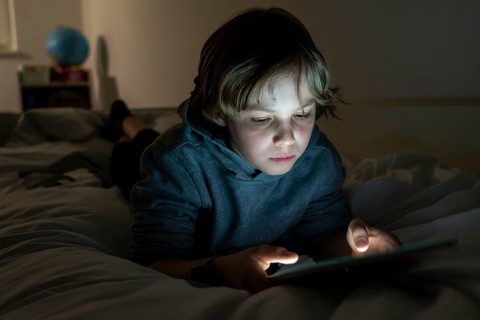 A boy plays computer games on a tablet PC