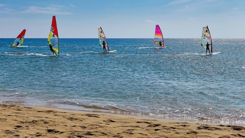 Windsurfer on the sea in sunny weather with colourful sails, surfer's paradise, kitesurfer,