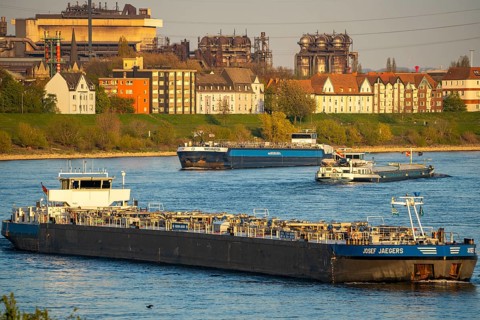 Cargo ships on the Rhine near Duisburg-Laar, houses on Deichstraße, industrial backdrop of the