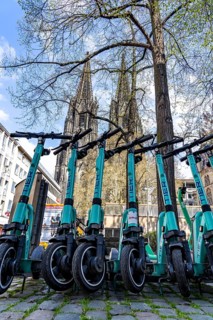 Electric scooters, e-scooters are parked in large numbers on the Burgmauer road, in front of