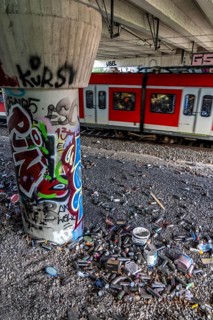 Empty spray paint cans, on a railway line below a road bridge, thrown away, disposed of by the