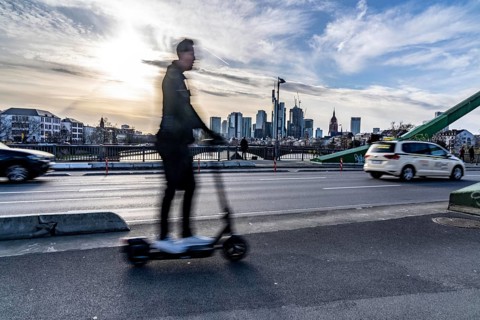 Skyline of Frankfurt am Main, skyscrapers, e-scooter rider on the Flößerbrücke, Hesse, Germany,