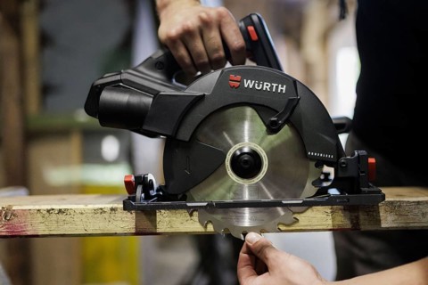 A man adjusts the cutting depth of a hand-held circular saw. Berlin, 14.08.2024
