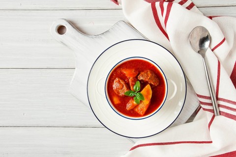 Potatoes stewed with meat, in tomato sauce, with spices and herbs, no people, on a white table