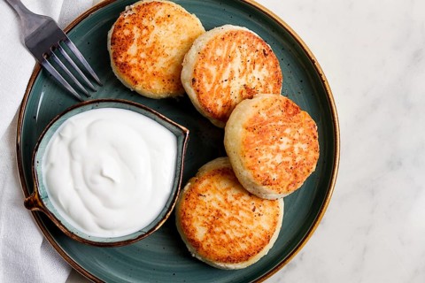 Fried, Cottage cheese pancakes, with sour cream, Cheesecakes, on a marble table, top view, no