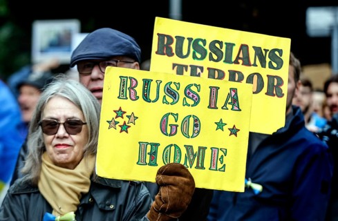 Ukrainians holding placards with the slogan Russia go home at the counter-demonstration Your peace