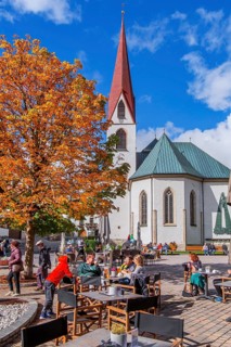 Village square with pilgrimage church of St. Oswald in autumn, Seefeld in Tyrol, Seefeld Plateau,