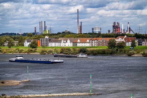 Cargo ship on the Rhine near Duisburg-Laar, houses on Deichstraße, industrial backdrop of the
