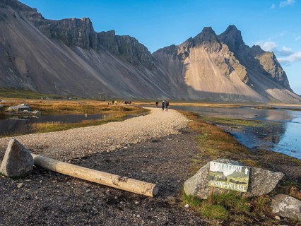 Tourists on path to viking village, rebuild viking houses at Stokksnes, east of Höfn, East Fjords,