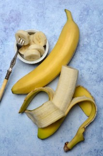 Opened banana and banana slices in peel