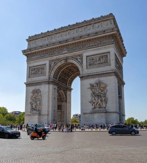 The Arc de Triomphe in Paris in sunny weather, surrounded by people and cars, Paris