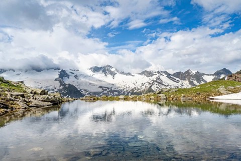 Picturesque mountain landscape with mountain lake, mountains and glaciers reflected in the