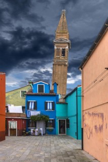 Colourful residential buildings, behind the leaning tower of the church of St. Martin Vescovo, 16th