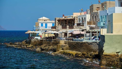 Picturesque coastal village with houses and balconies on the blue water, sunny atmosphere,