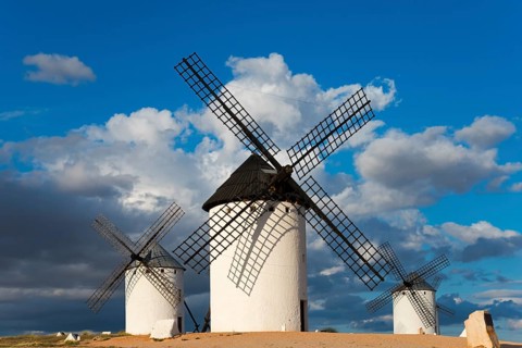Three windmills stand in an open landscape under a cloudy but sunny sky, Windmills, Campo de