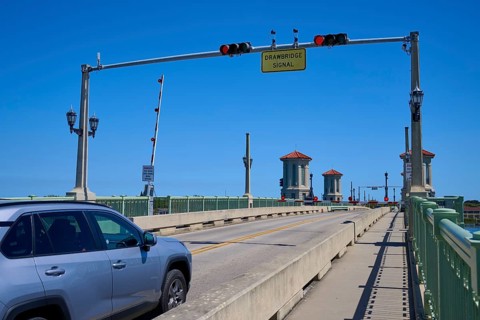 Traffic light, drawbridge and a car, with a sign, Bridge of Lions, pointing to a drawbridge, St.