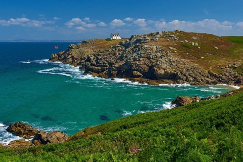 Lighthouse house Phare du Millier on cliff overlooking the sea under a clear sky, Point du Millier,
