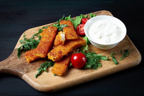 Fried fish nuggets, with white sauce, arugula and cherry, no people