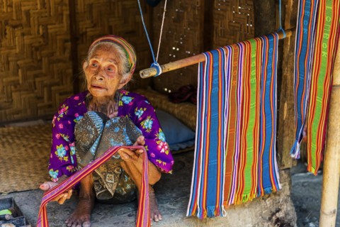 Old woman offering textiles for sale, textile, old age, human, work, colourful, clothing, village,