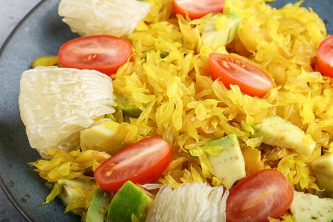 Fried pomelo with tomatoes and avocado on gray concrete background, close up, myanmar food