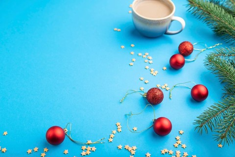 Christmas or New Year composition. Decorations, red balls, fir and spruce branches, cup of coffee,