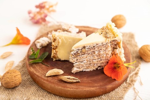 Walnut and almond cake on white wooden background and linen textile. side view, close up, selective