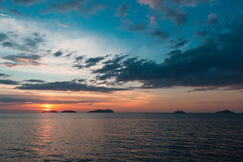 Beautiful purple sunset on the sea with small islands on the horizon
