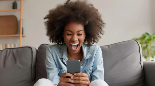 Younge black happy girl playing on smartphone apps, betting money online and shopping online, AI